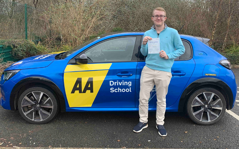 Driving student Marcus holds up his certificate after passing his driving test